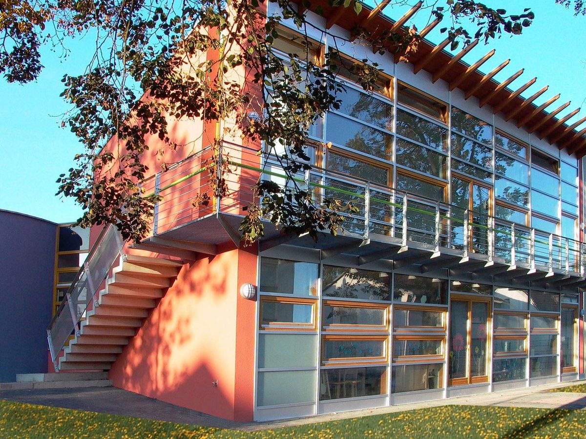 Anbau des Kindergartens St. Peter mit roter Fassade und Glasfront