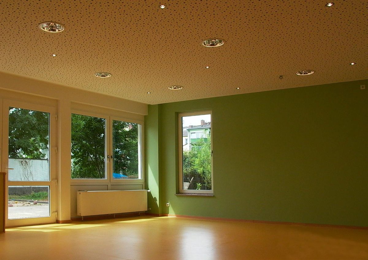 Leerer Gruppenraum mit grüner Wand und Fensterfront